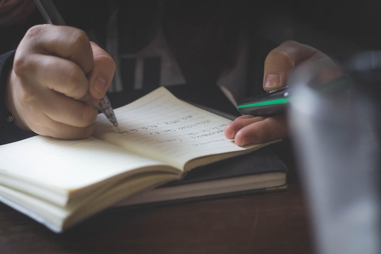 An open notebook and study materials laid out on a desk